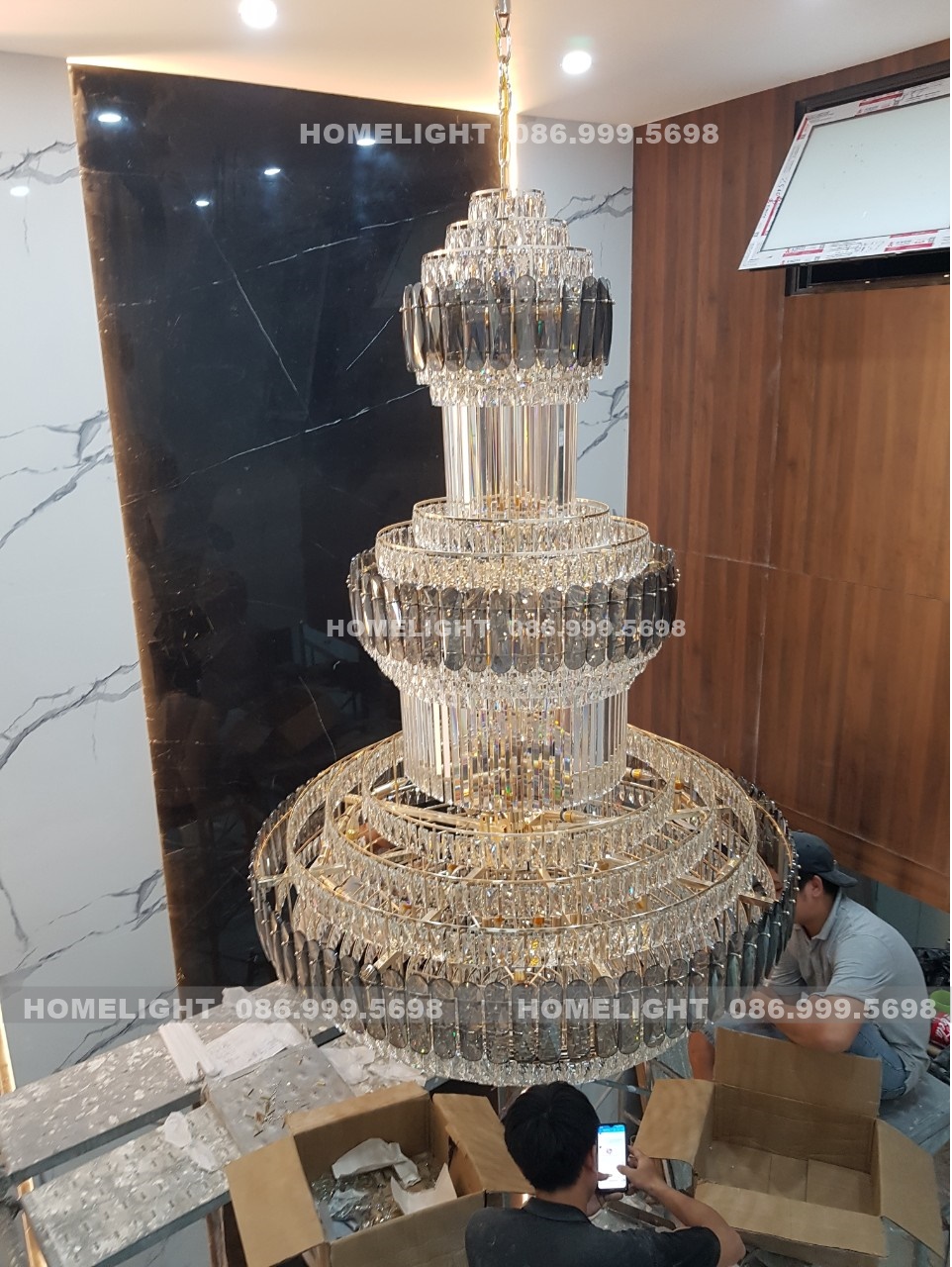 Đèn chùm pha lê nhiều tầng thiết kế riêng cho khoảng thông tầng Villa Thạch Thất, thợ HomeLight đang hoàn thiện